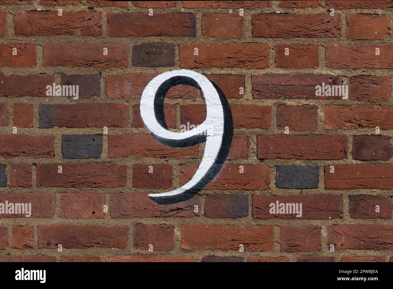 Il numero 9 / nove dipinto su un muro di mattoni Foto Stock