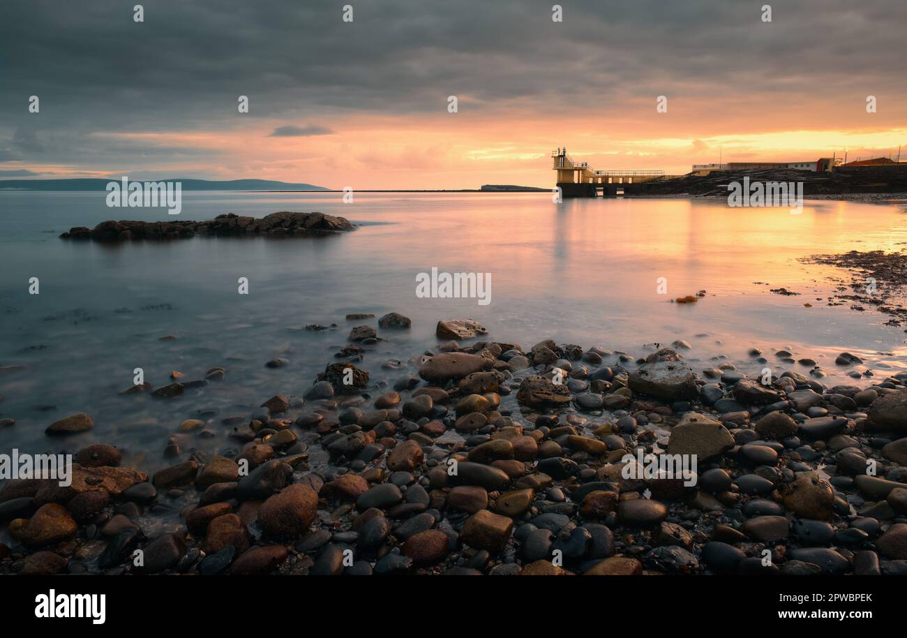 Spettacolare tramonto nuvoloso paesaggio marino di Blacrock diving torre sulla spiaggia di Salthill a Galway, Irlanda Foto Stock