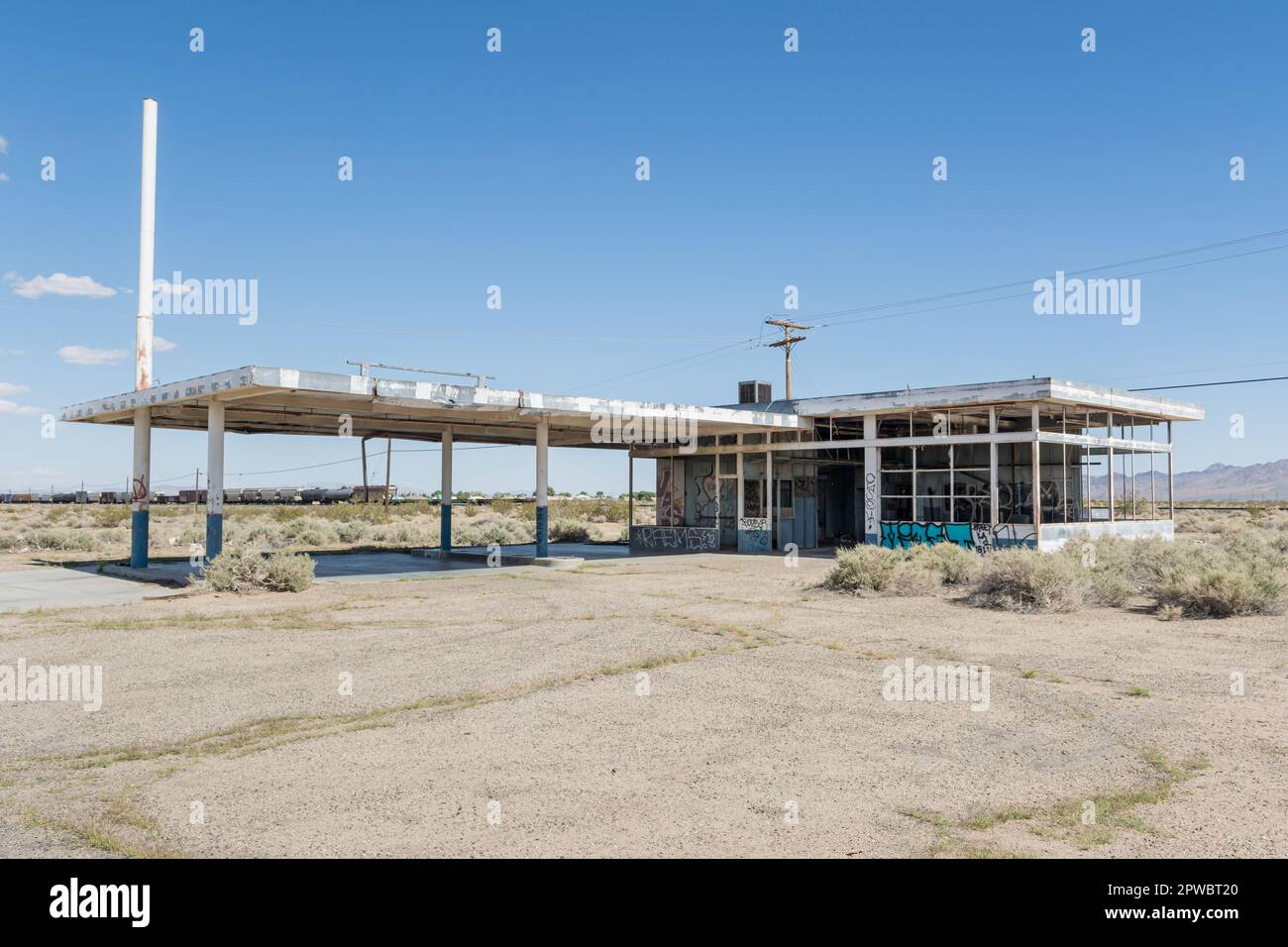 Una stazione di servizio abbandonata si trova lungo i binari ferroviari di Yermo, nel deserto del Mojave, nella California meridionale. Foto Stock