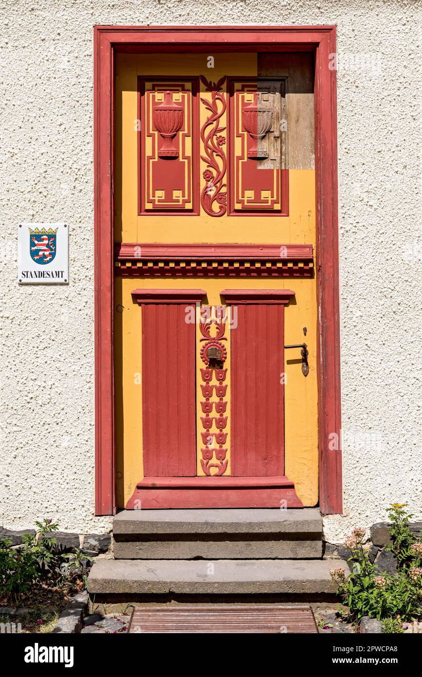 Storica porta in legno con sculture dipinte, ingresso all'ufficio del registro, casa di Muenchhausen, Museo all'aperto di Hessenpark, Neu-Anspach, Taunus Foto Stock