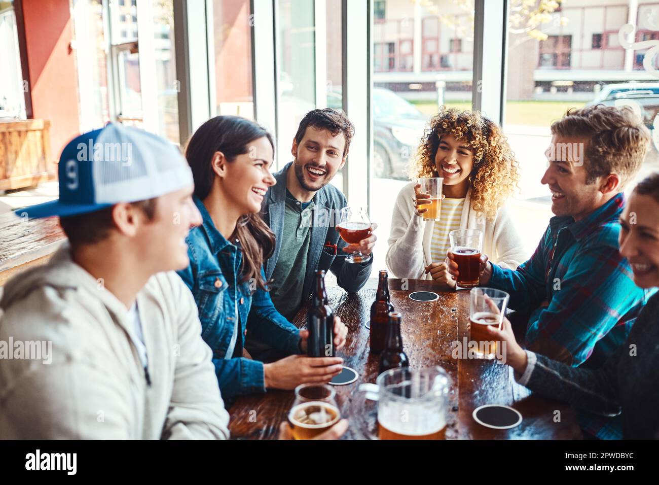 Il divertimento è iniziato. un gruppo di amici che gustano delle birre in un bar. Foto Stock