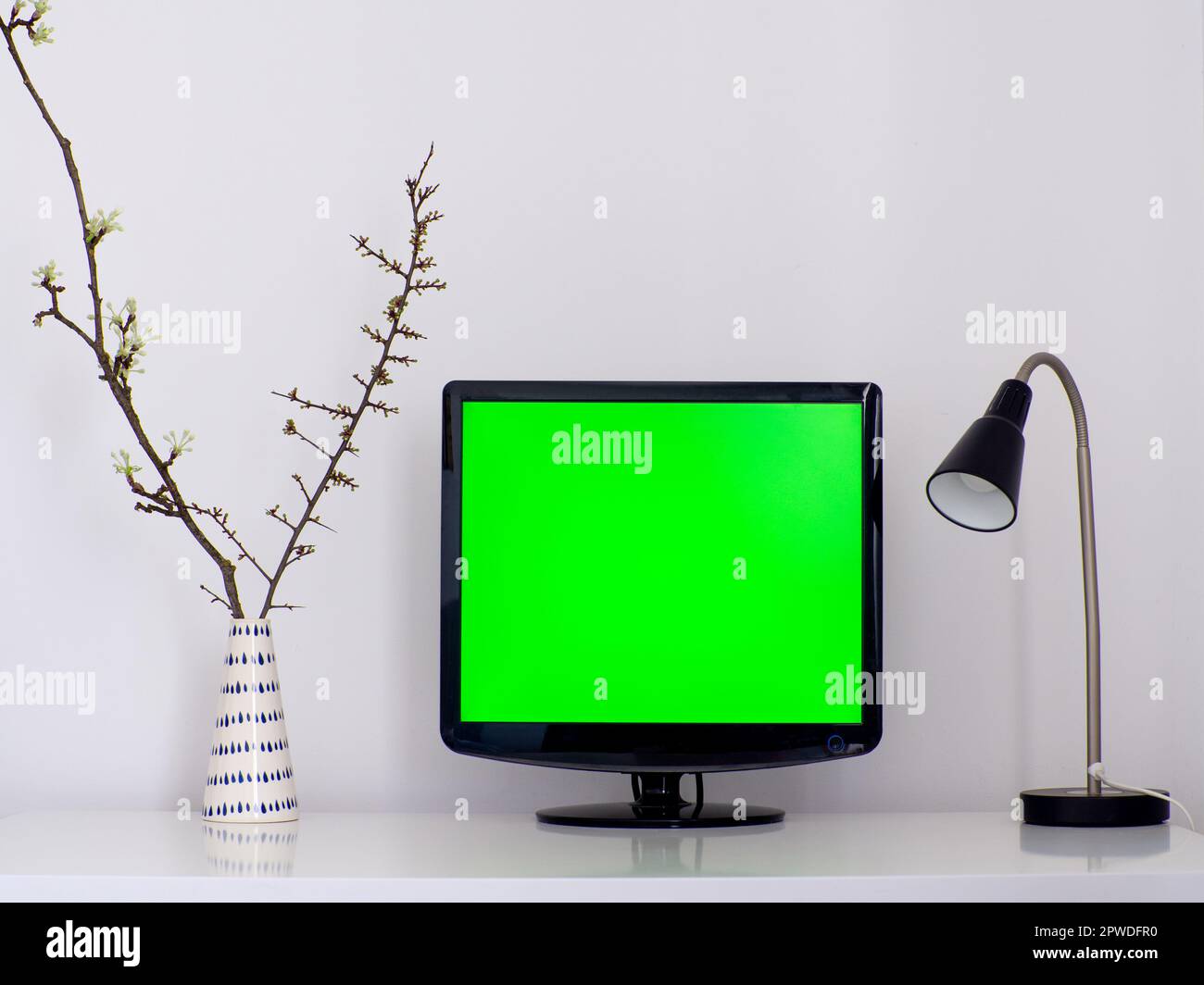 Computer desktop con schermo vuoto in una stanza d'ufficio minimale con decorazioni e spazio per le copie. Area di lavoro mockup sul tavolo bianco. Ufficio domestico. Lavoro, lavoro Foto Stock