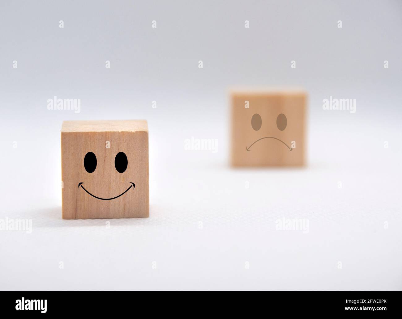 Faccie allegre e tristi su cubi di legno con copertura di fondo bianca. Feedback dei clienti, soddisfazione e valutazione. Foto Stock