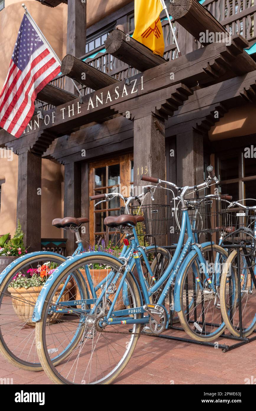 Facciata esterna dell'Inn of the Anasazi, hotel boutique appena fuori dal centro di Plaza, Santa Fe, New Mexico, con Bandiera americana e biciclette color turchese. Foto Stock