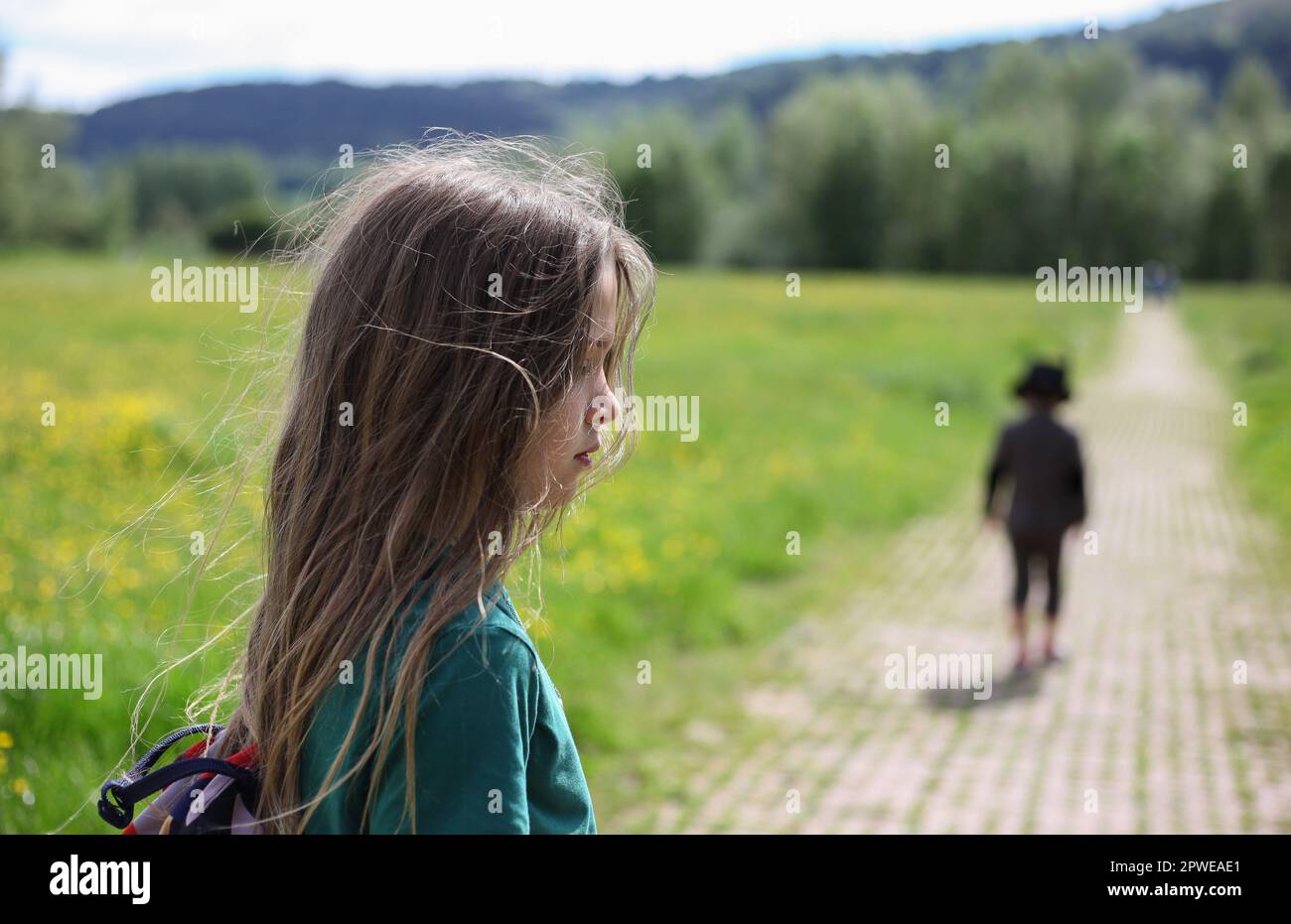 Bambino con lunghi capelli a piedi in campagna Foto Stock
