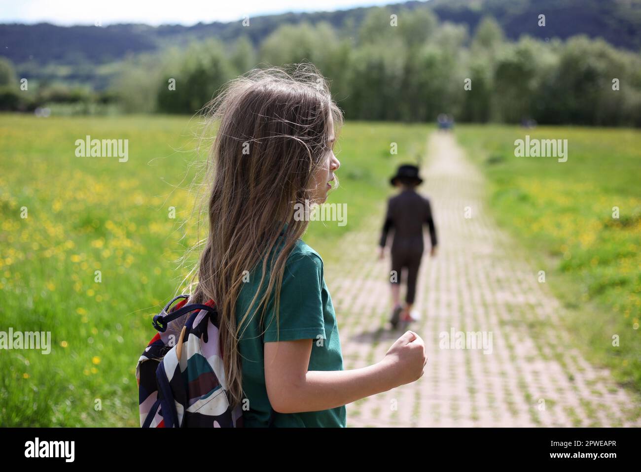 Bambino con lunghi capelli a piedi in campagna Foto Stock