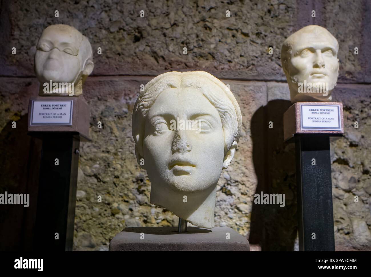 Una testa di marmo scolpita del 2nd ° secolo d.C. di una donna, fiancheggiata da due teste scolpite di uomini, in mostra nel Side Museum, provincia di Antalya, Turchia (Turkiye). Il Foto Stock