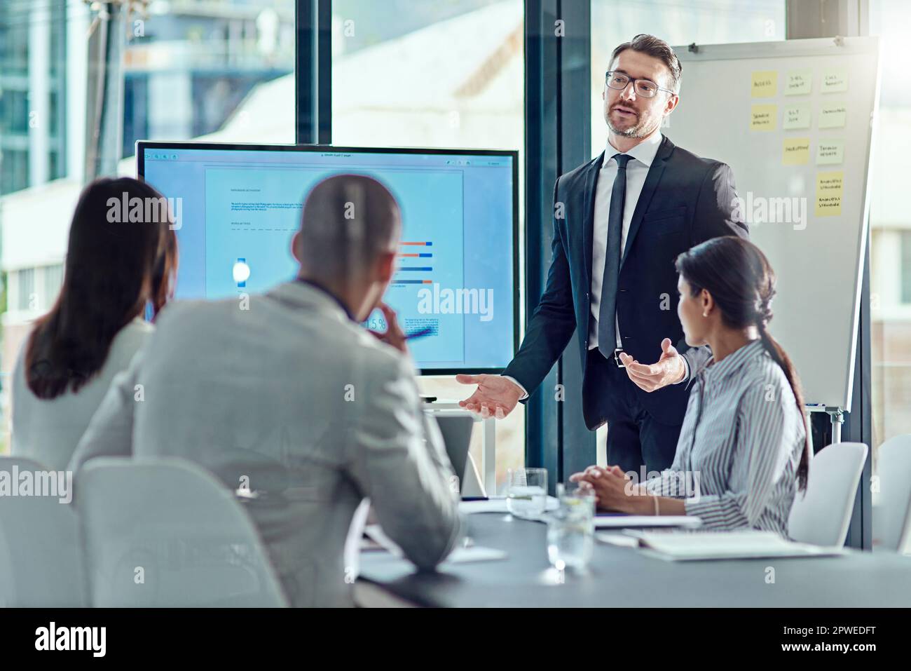 Cmon ragazzi, dovresti saperlo. un uomo d'affari che offre una presentazione nella sala riunioni. Foto Stock