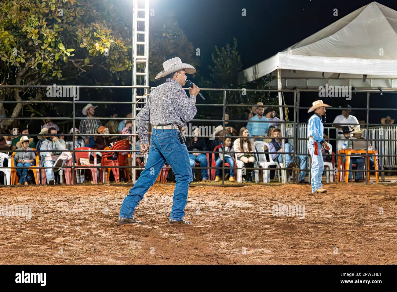 Itaja, Goias, Brasile - 04 21 2023: Annunciatore regionale del rodeo con microfono in un'arena del rodeo Foto Stock