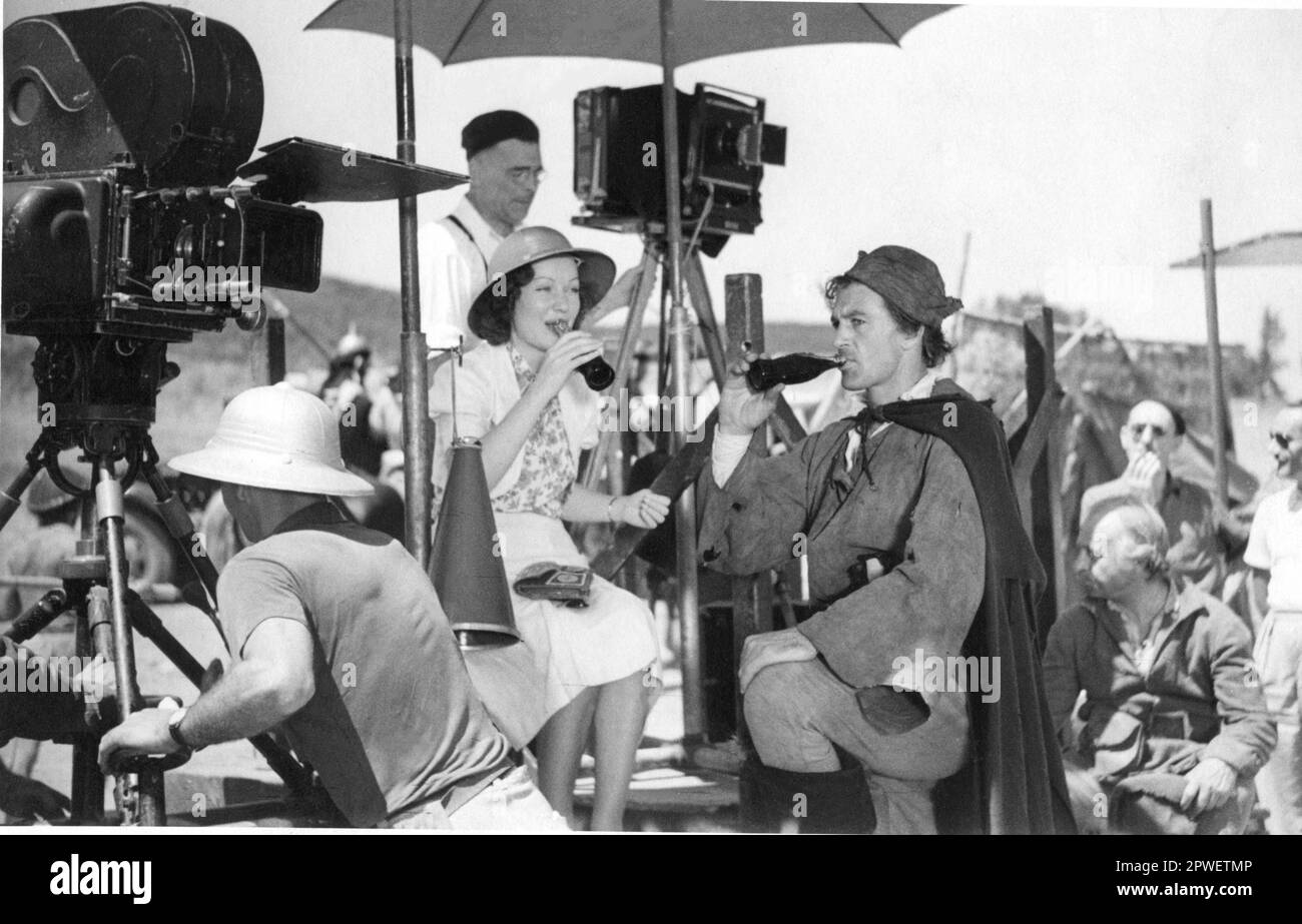 GARY COOPER e la sua leader SIGRID GURIE si rinfrescano con una bottiglia di Coca-Cola mentre sono sul posto per LE AVVENTURE DI MARCO POLO 1938 regista ARCHIE MAYO Story N.A. POGSON sceneggiatura ROBERT E. SHERWOOD Music HUGO FRIEDHOFER Samuel Goldwyn / United Artists Foto Stock