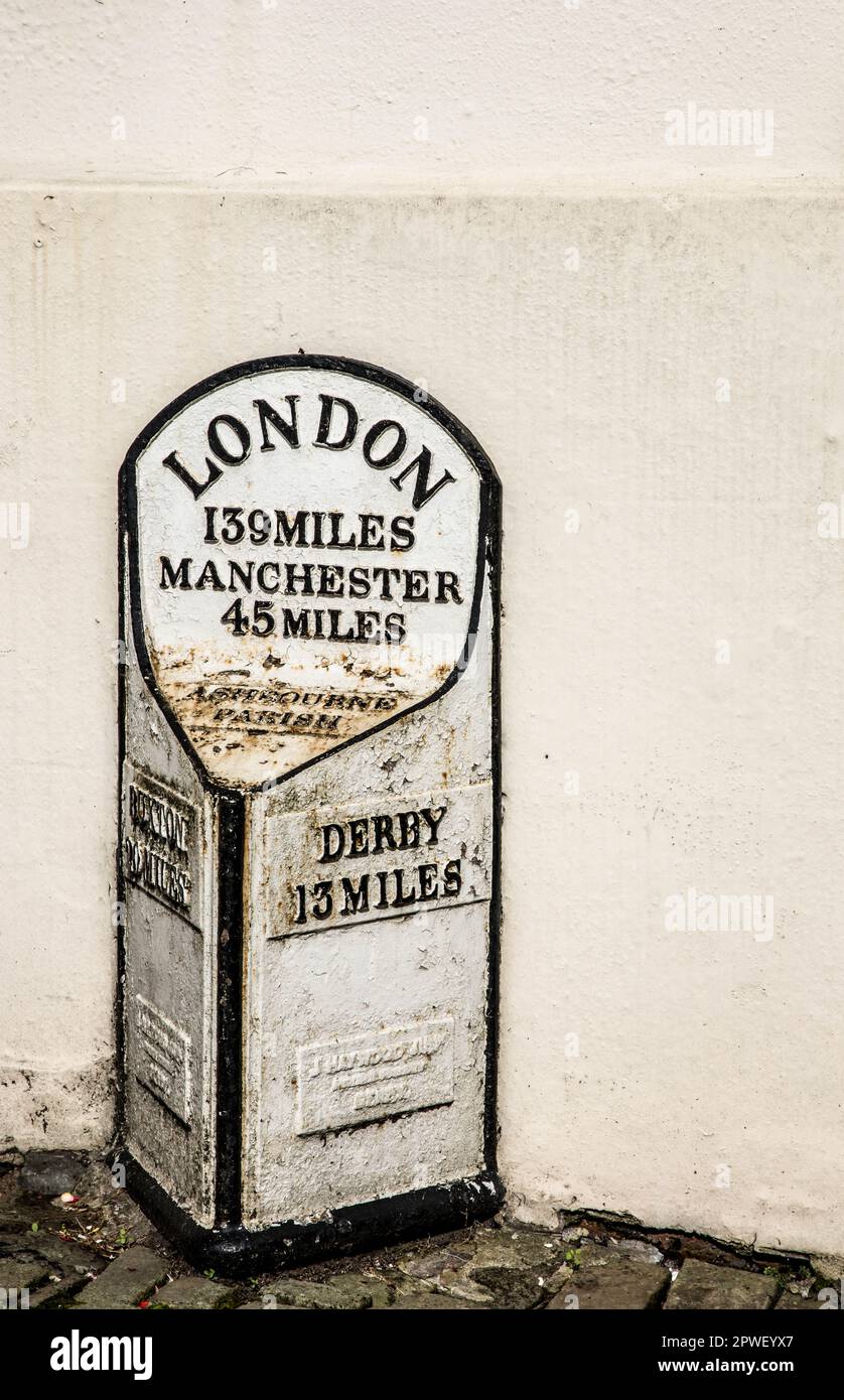 White Mile marker con dettagli neri nella Ashbourne Parish, Derbyshire, che raffigura la distanza da Londra, Derby, Manchester. Foto Stock