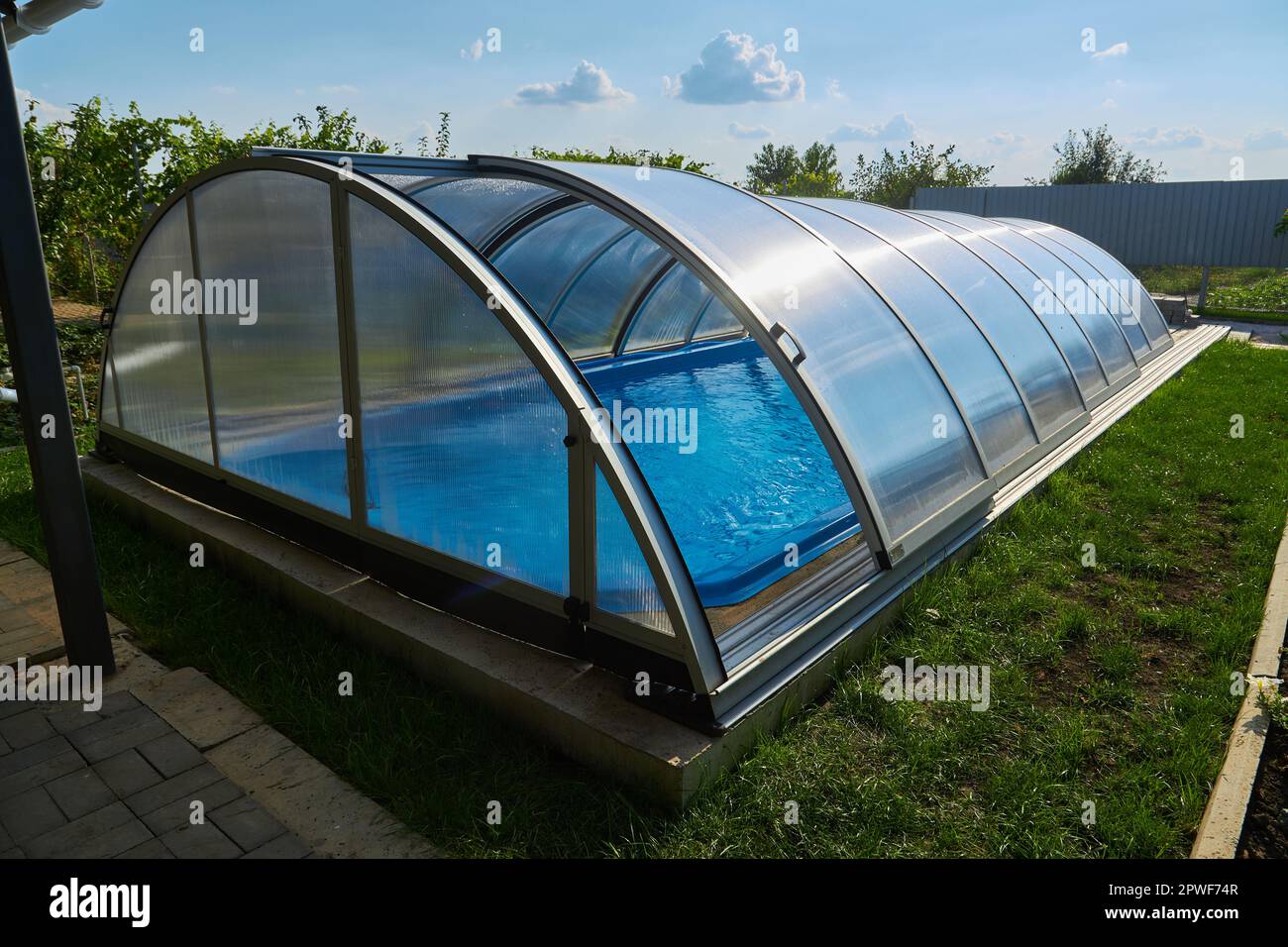 Piscina all'aperto con coperchio scorrevole. Protezione contro le intemperie Foto Stock