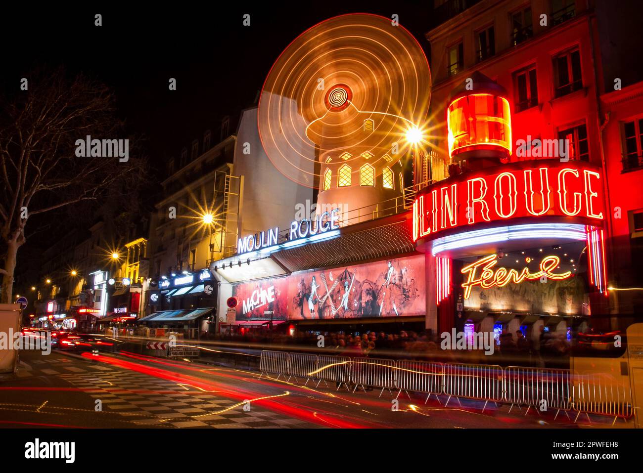 Facciata del cabaret Moulin Rouge nel quartiere dei divertimenti di Pigalle vicino a Montmartre a Parigi, Francia - movimento sfocato su un illuminato rotante Foto Stock