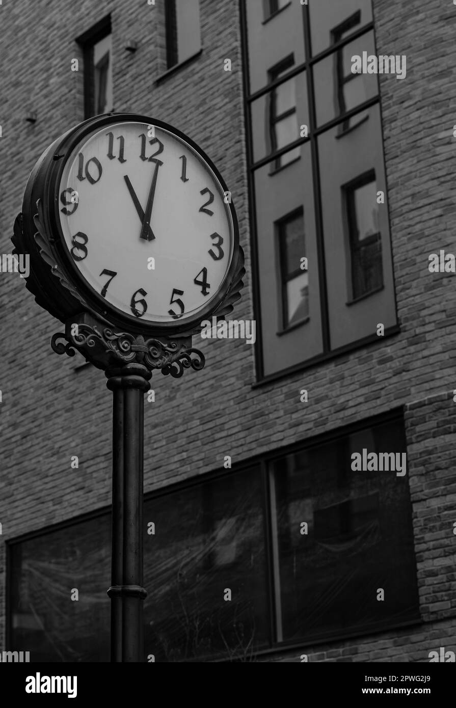 Una splendida fotografia in bianco e nero di un orologio da parete a Bielsko Biala Polonia con il suo grande volto contro l'esterno architettonico di un imponente bu Foto Stock