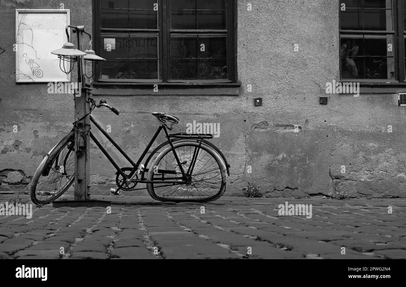 Vecchia bicicletta retrò un viaggio monocromatico attraverso una fotografia di strada di paesaggio urbano. Foto Stock