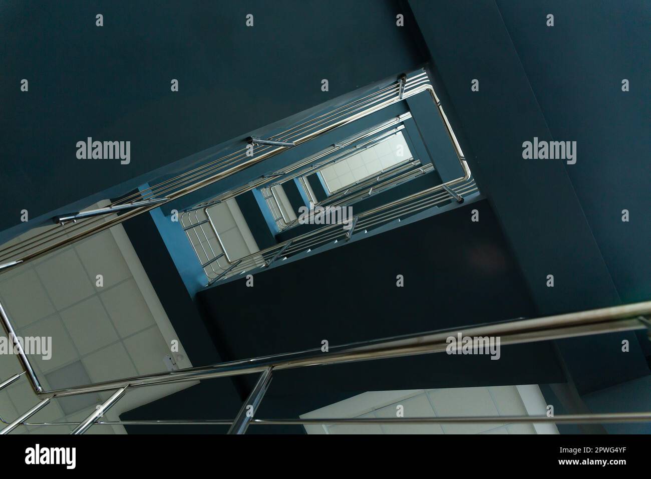 Scale in un edificio in cemento da ufficio in tonalità neutre, ricoperte di piastrelle in ceramica, con ringhiere in metallo lucido in acciaio inossidabile, ampia vetrata Foto Stock