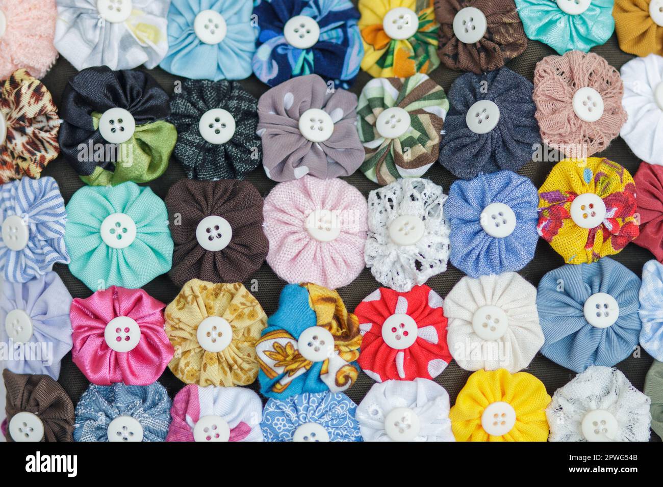 L'artigianato yo-yo è composto da diversi piccoli fasci di vestiti che, cuciti insieme, danno origine a fiori di diversi colori. interni a rio de Foto Stock