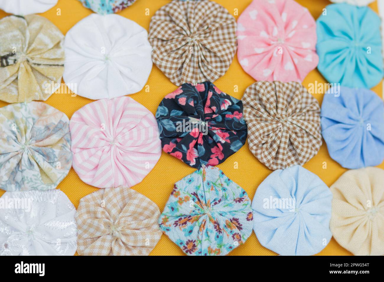 L'artigianato yo-yo è composto da diversi piccoli fasci di vestiti che, cuciti insieme, danno origine a fiori di diversi colori. interni a rio de Foto Stock