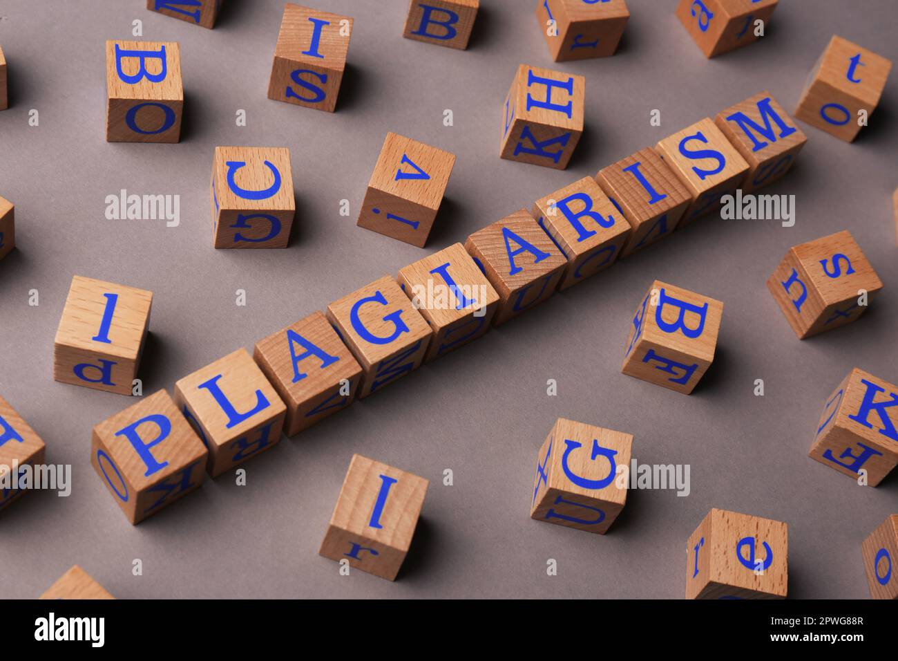 Cubi di legno con plagio di parola su sfondo grigio Foto Stock