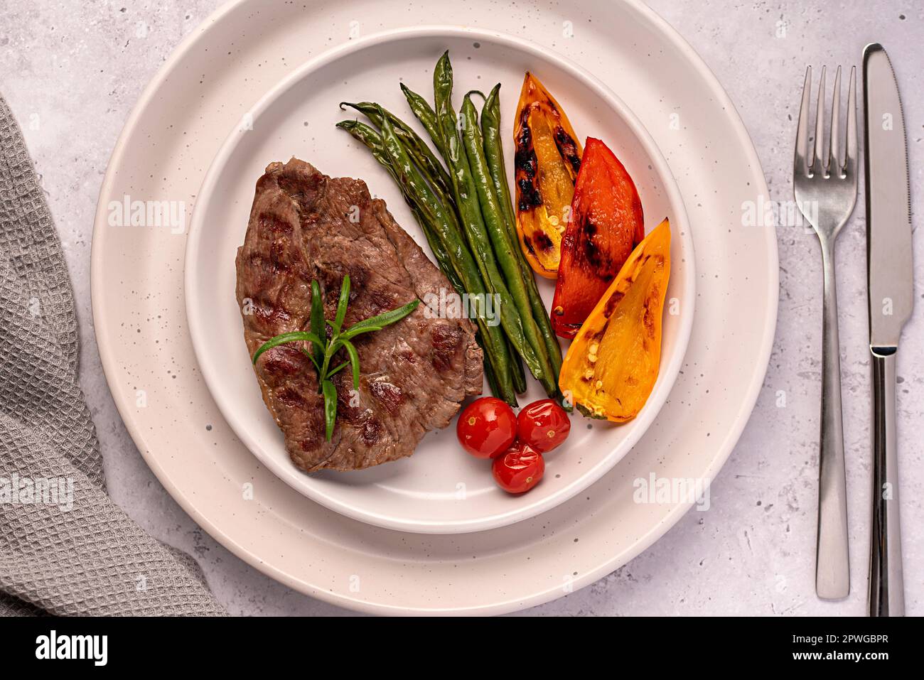 Fotografia alimentare di bistecca di agnello arrosto, alla griglia, carne, filetto, fagiolini, paprika, pomodori ciliegini Foto Stock