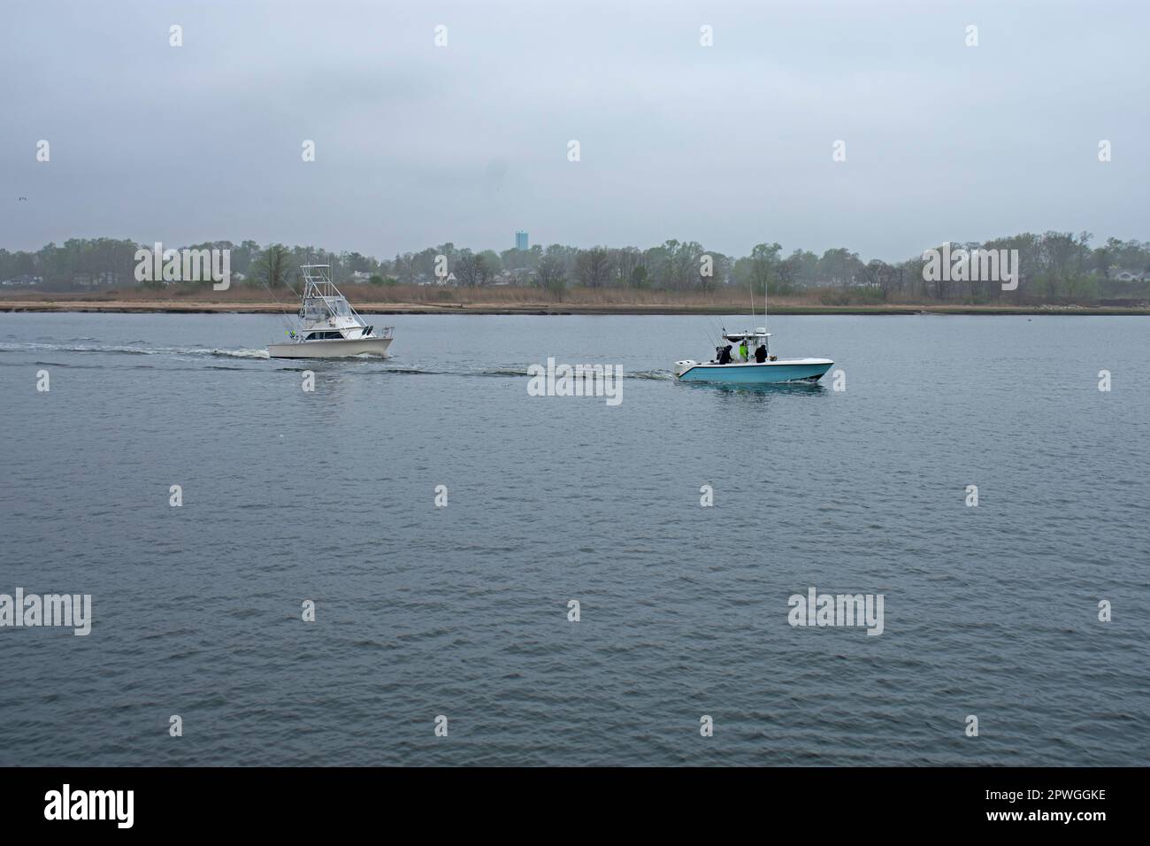 Barche da pesca da diporto, alcune iniziano e alcune terminano la giornata di pesca, in una mattina di primavera nebbiosa a Keyport Harbor, New Jersey -10 Foto Stock