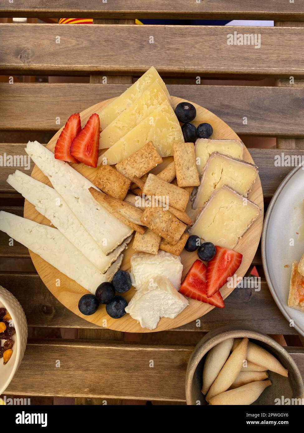 Diverse gustose fette di formaggio preparate con fragole e frutta su un tavolo di legno Foto Stock