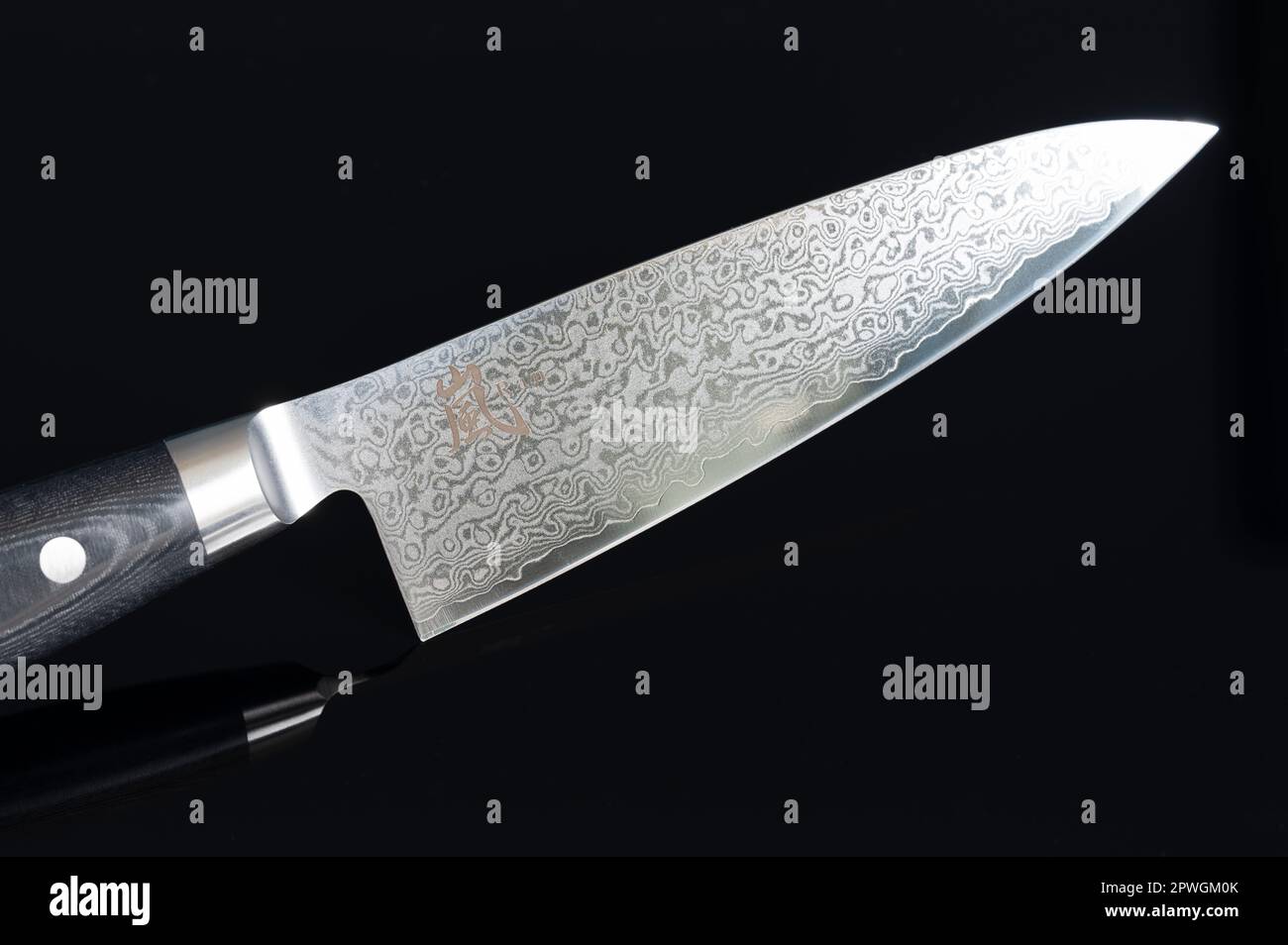Un tradizionale coltello da chef giapponese di prima qualità prodotto con acciaio damasco ripiegato a strati Foto Stock