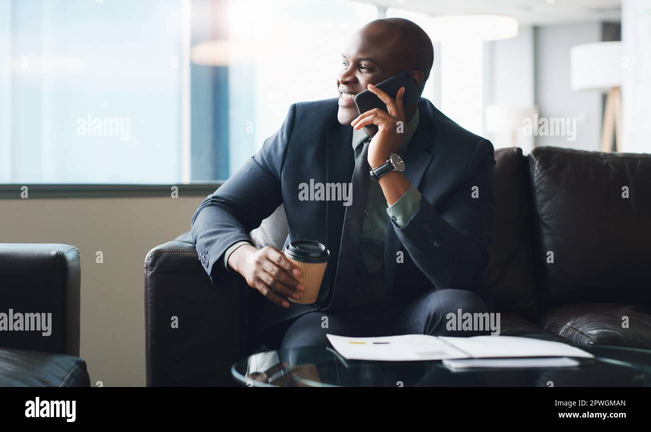 Youll sempre ricevere buone notizie se youre un lavoratore duro. un uomo d'affari che parla sul suo cellulare mentre si siede in un ufficio moderno. Foto Stock