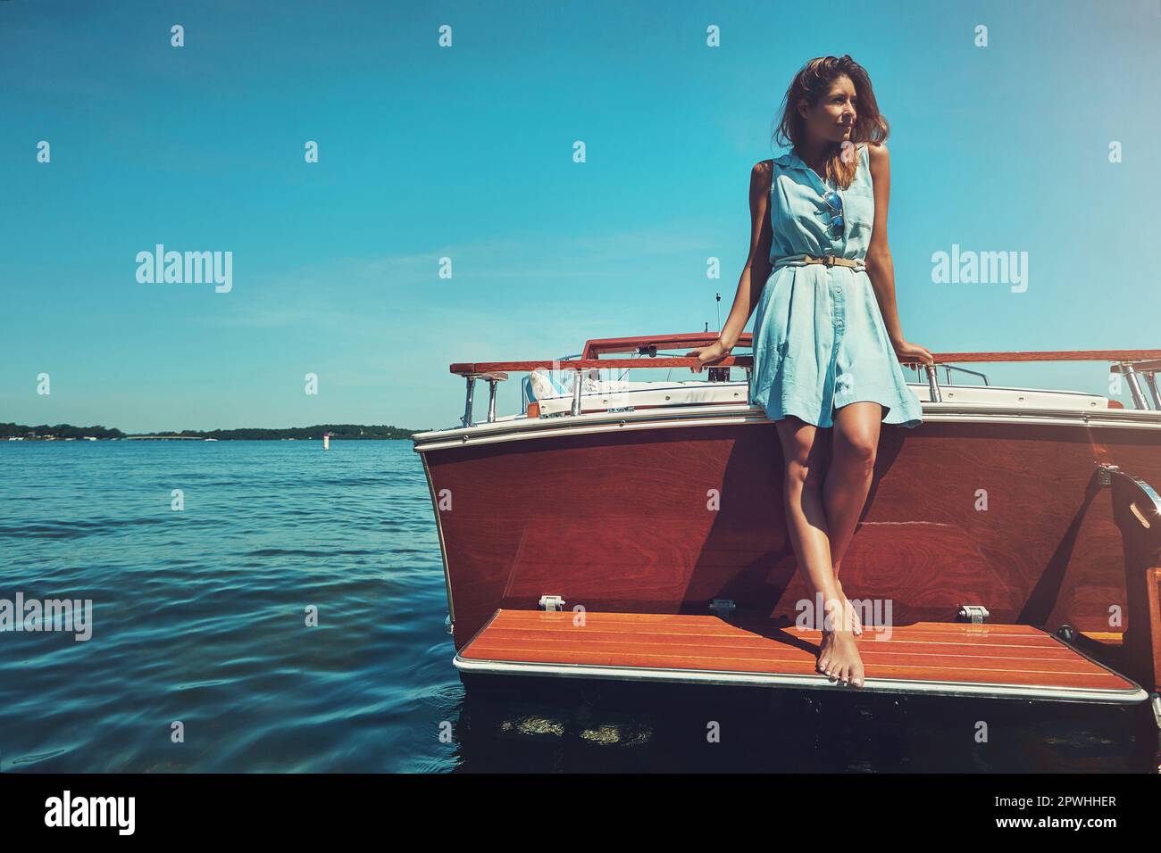 Prendere una barca lenta in qualche luogo bello. una giovane donna attraente che trascorre la giornata sul suo yacht privato. Foto Stock