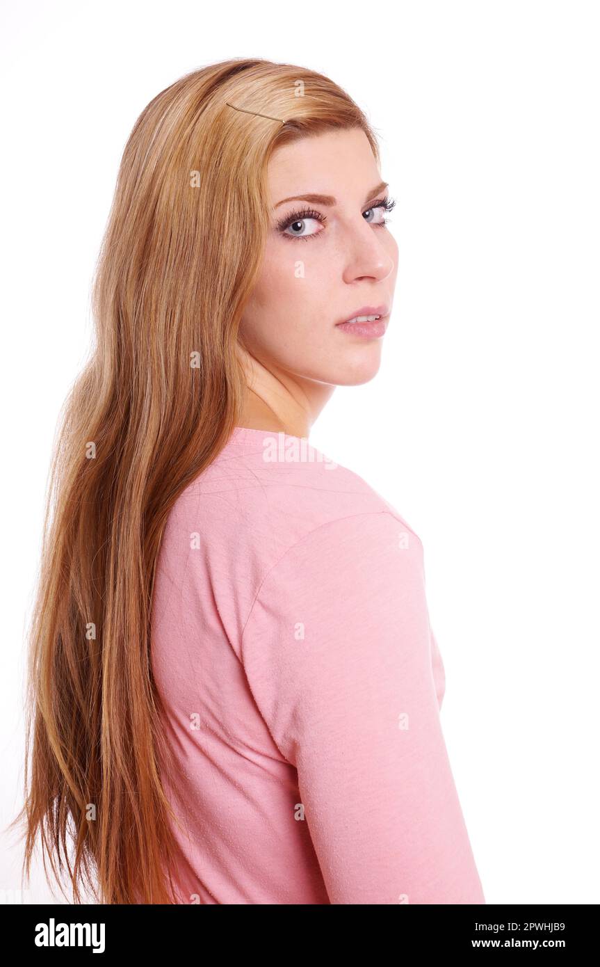 Ritratto di una giovane donna con capelli lunghi biondi guardando sopra la sua spalla Foto Stock