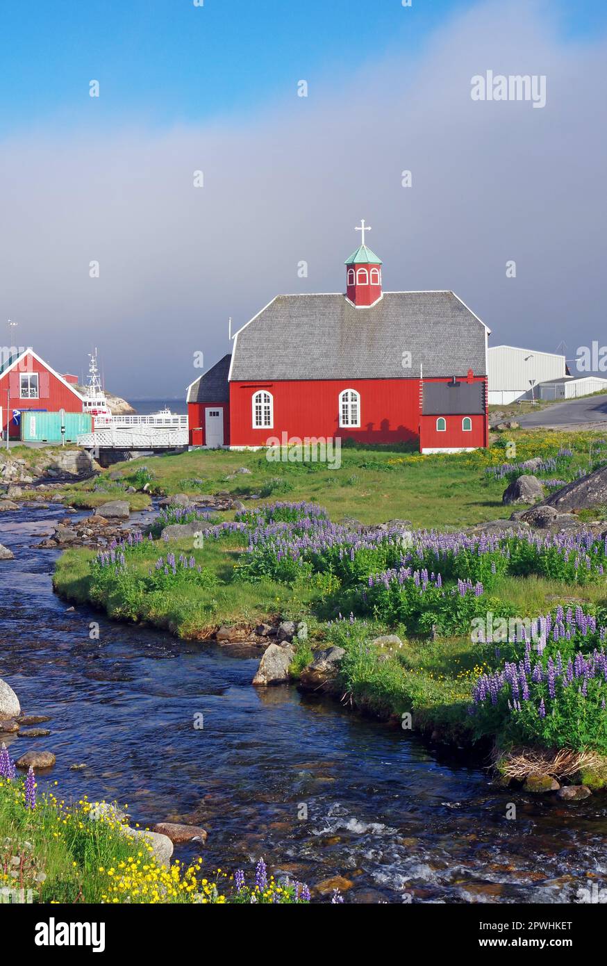 Piccolo ruscello e fiori, vecchia chiesa a Qaqortoq, comune di Kujalleq, Artico, Groenlandia, Danimarca Foto Stock