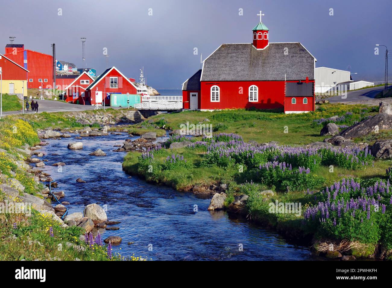 Piccolo ruscello e fiori, vecchia chiesa a Qaqortoq, comune di Kujalleq, Artico, Groenlandia, Danimarca Foto Stock
