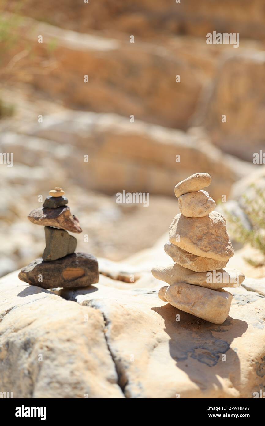 Le pietre della piramide equilibrano sulla roccia di sabbia. L'oggetto è a fuoco, lo sfondo è sfocato Foto Stock