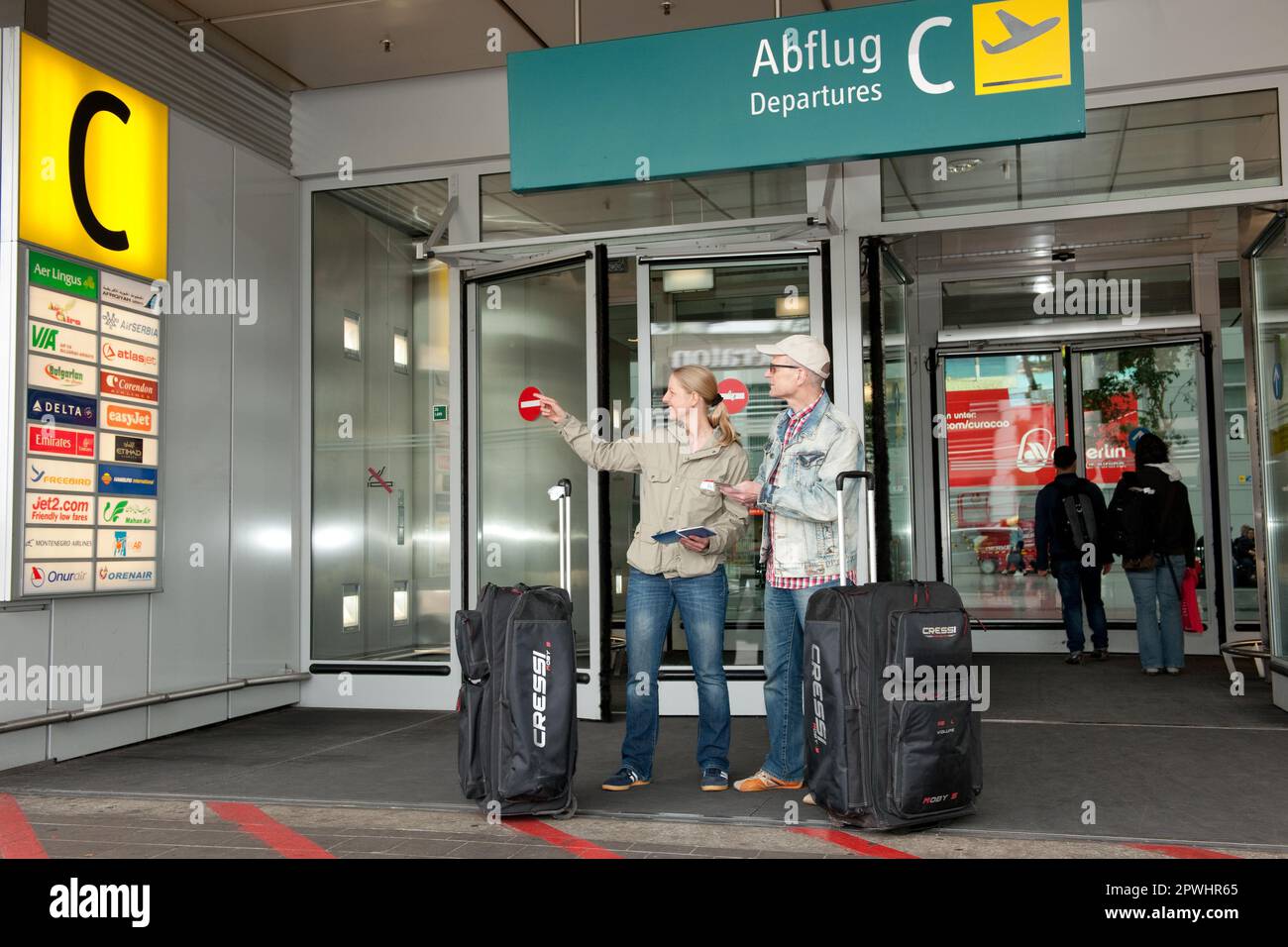 Vacanzieri con bagagli, in aeroporto guardando a bordo con il logo della compagnia aerea, Duesseldorf, Nord Reno-Westfalia, Germania Foto Stock