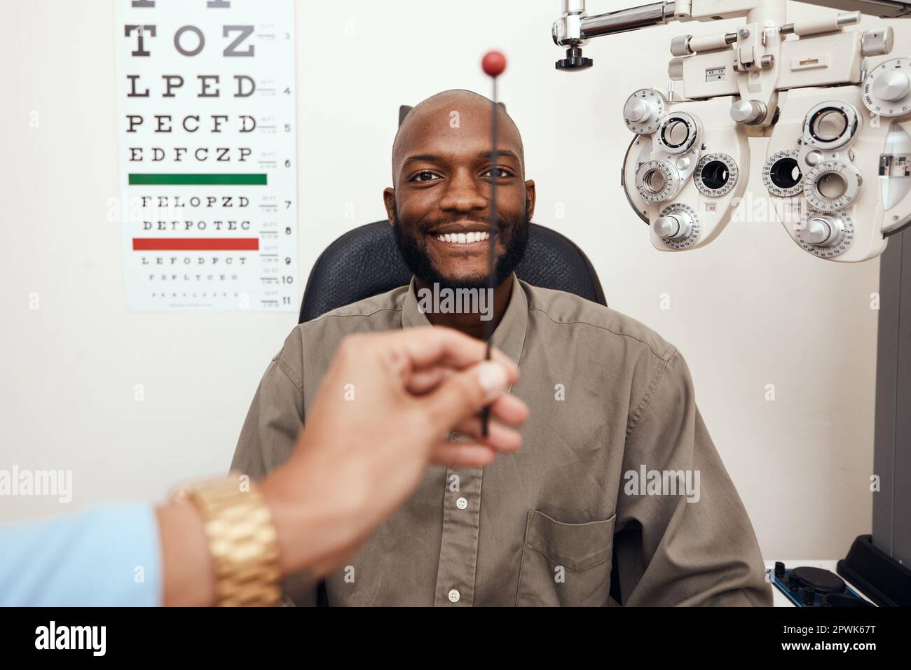 Uomo nero che ha i suoi occhi testati ad un optometrista. Sorridente afroamericano consulenza maschile con un opthamologist, avendo una visione e cura degli occhi controllo Foto Stock