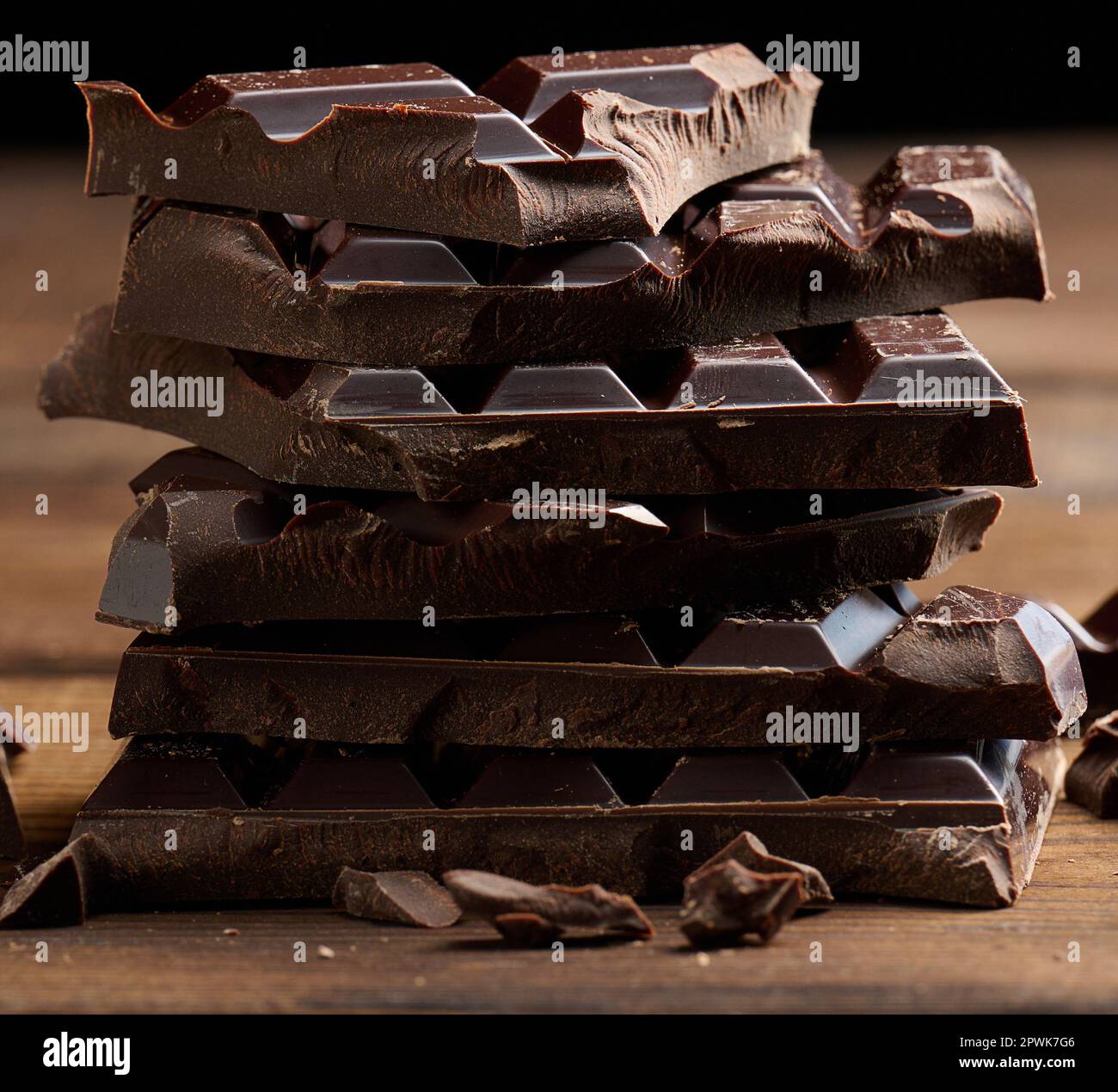 Pila di cioccolato rotto su tavolo di legno Foto Stock