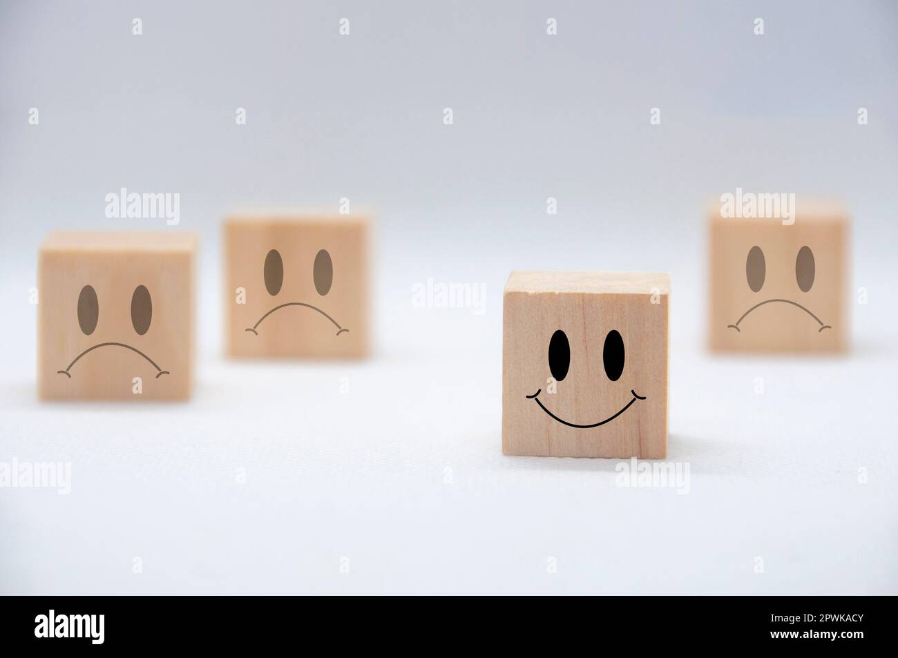 Emozioni felici e tristi su cubi di legno. Soddisfazione del cliente e concetto di valutazione Foto Stock