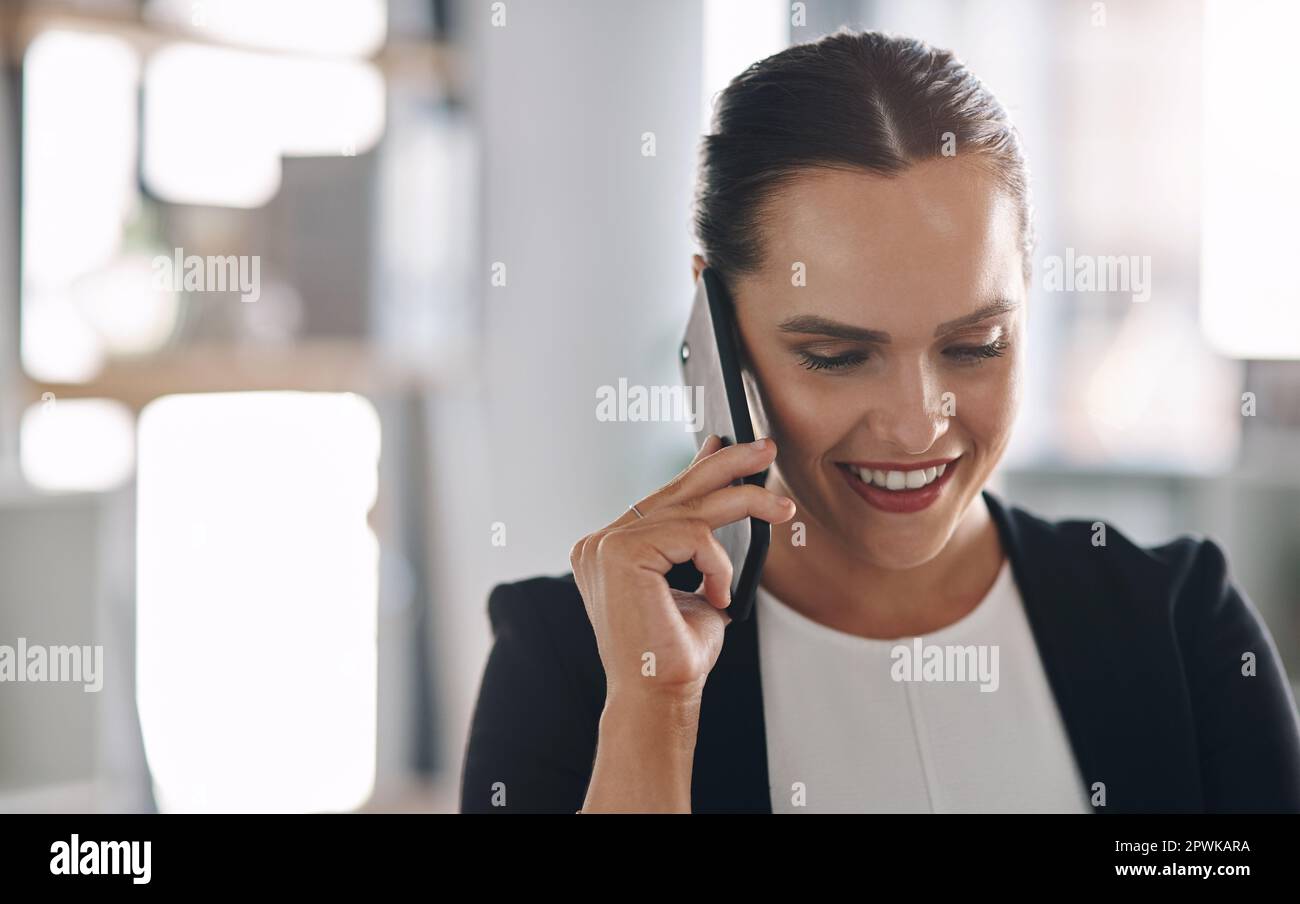 Il successo è arrivato chiamando al momento giusto. una giovane e attraente donna d'affari che risponde a una telefonata all'interno del suo ufficio Foto Stock