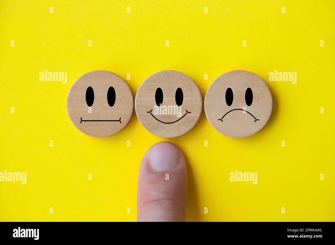 Facce di emozione neutre, felici e tristi su cubi di legno. Soddisfazione del cliente e concetto di valutazione Foto Stock