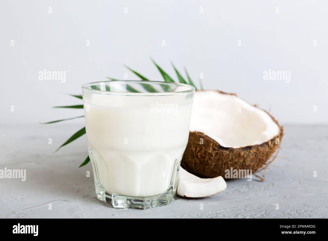 prodotti di cocco su sfondo tavolo di legno bianco. Latte senza latte di sostituzione bevanda, piatto Lay sano mangiare. Foto Stock