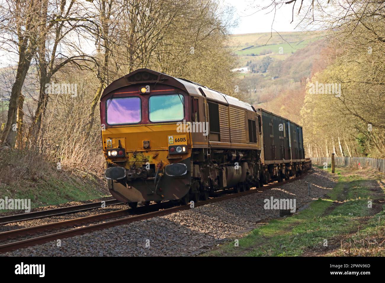 Locomotiva diesel-elettrica 66015 che tira container, Mytholmroyd, West Yorkshire Foto Stock