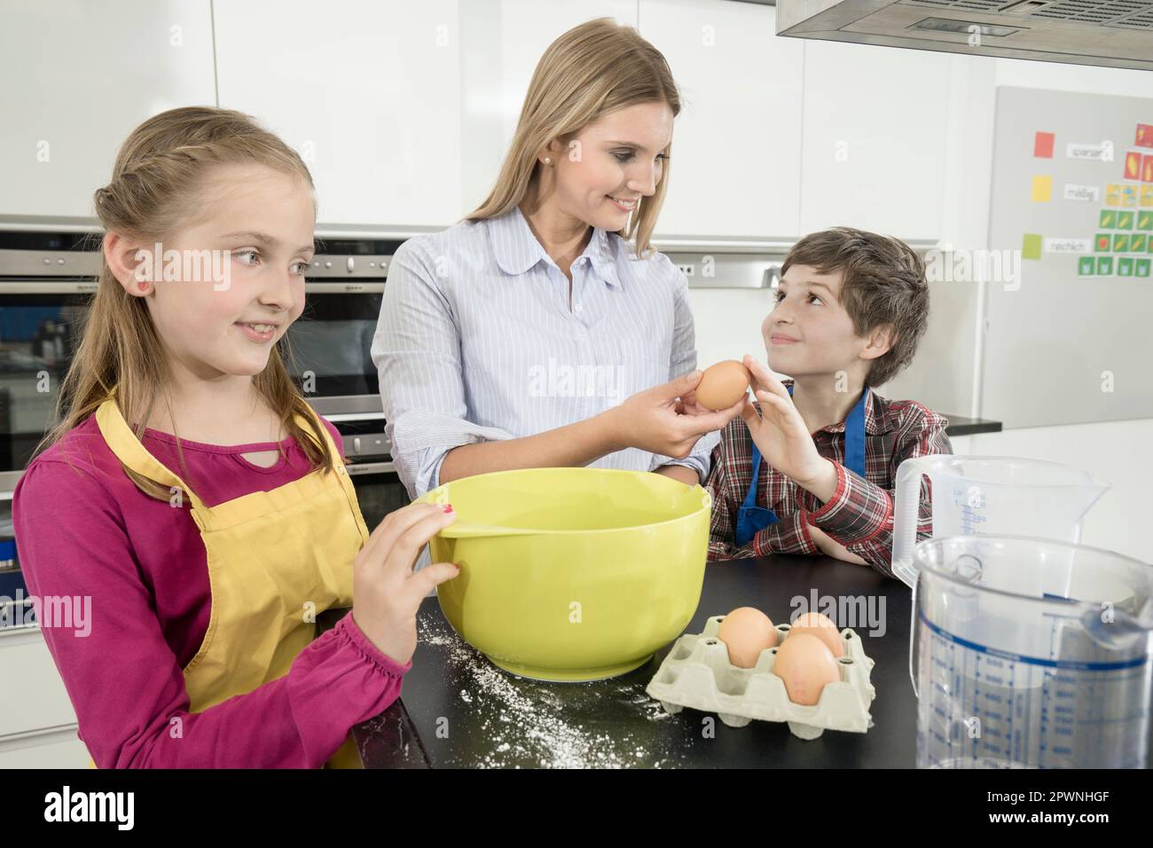 Insegnante che dà un uovo allo studente in una classe di economia domestica, Baviera, Germania Foto Stock