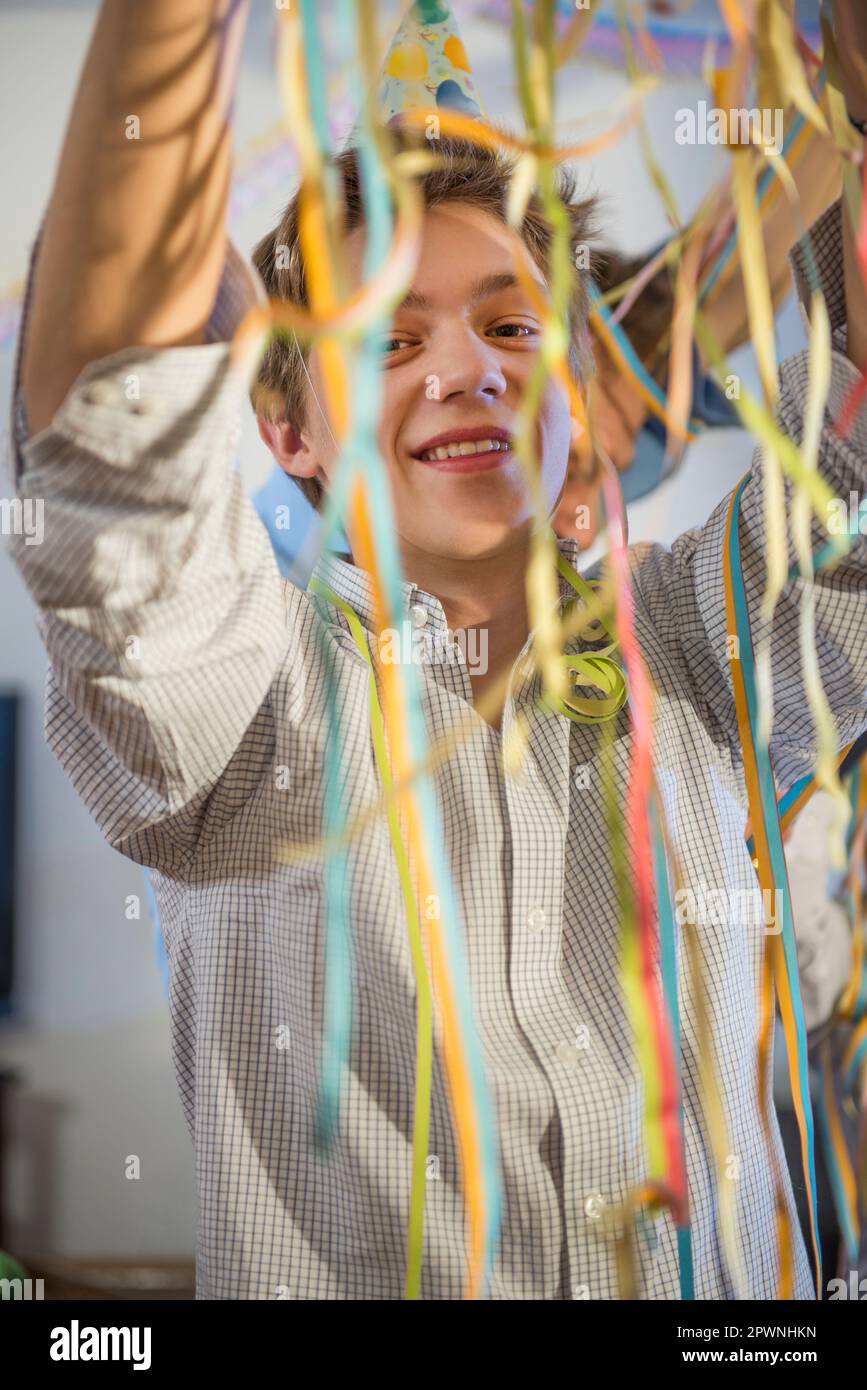 Adolescente con carta streamers alla festa di compleanno Foto Stock