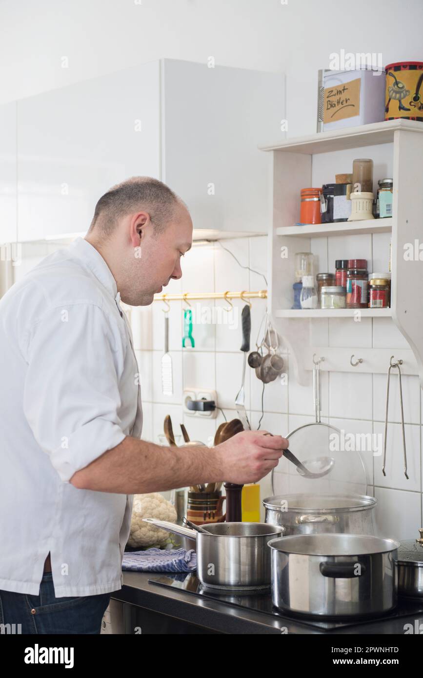 Cuoci il cibo in pentole sulla stufa Foto Stock