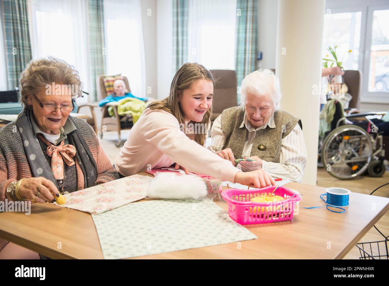 Le donne anziane con la ragazza che fa l'attività del mestiere a casa di riposo Foto Stock