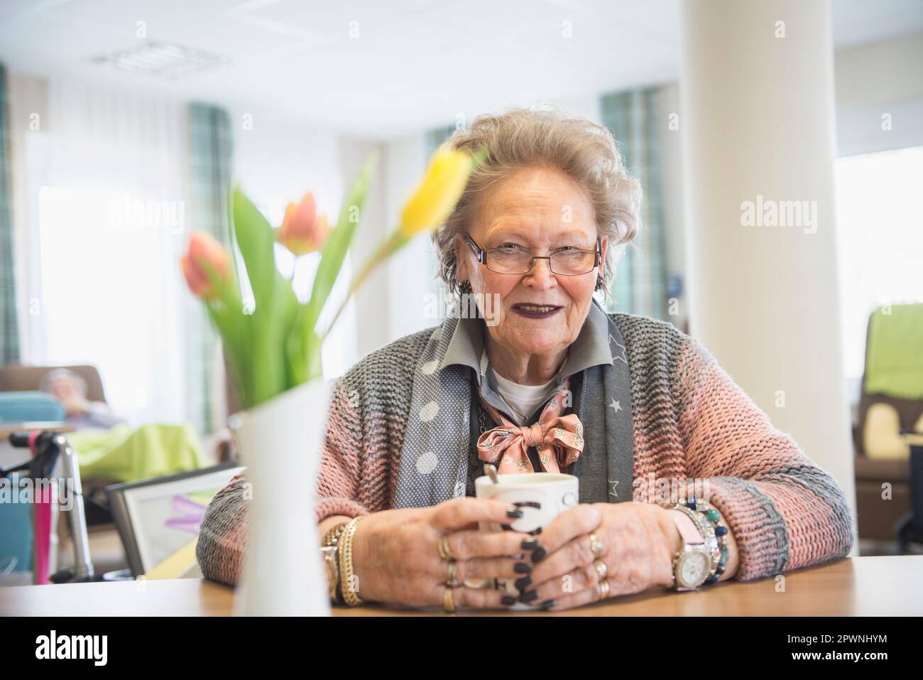Donna anziana con caffè a casa di riposo Foto Stock