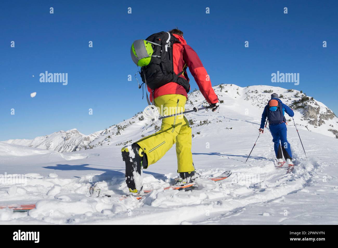 Vista posteriore degli sciatori che camminano verso la montagna Foto Stock
