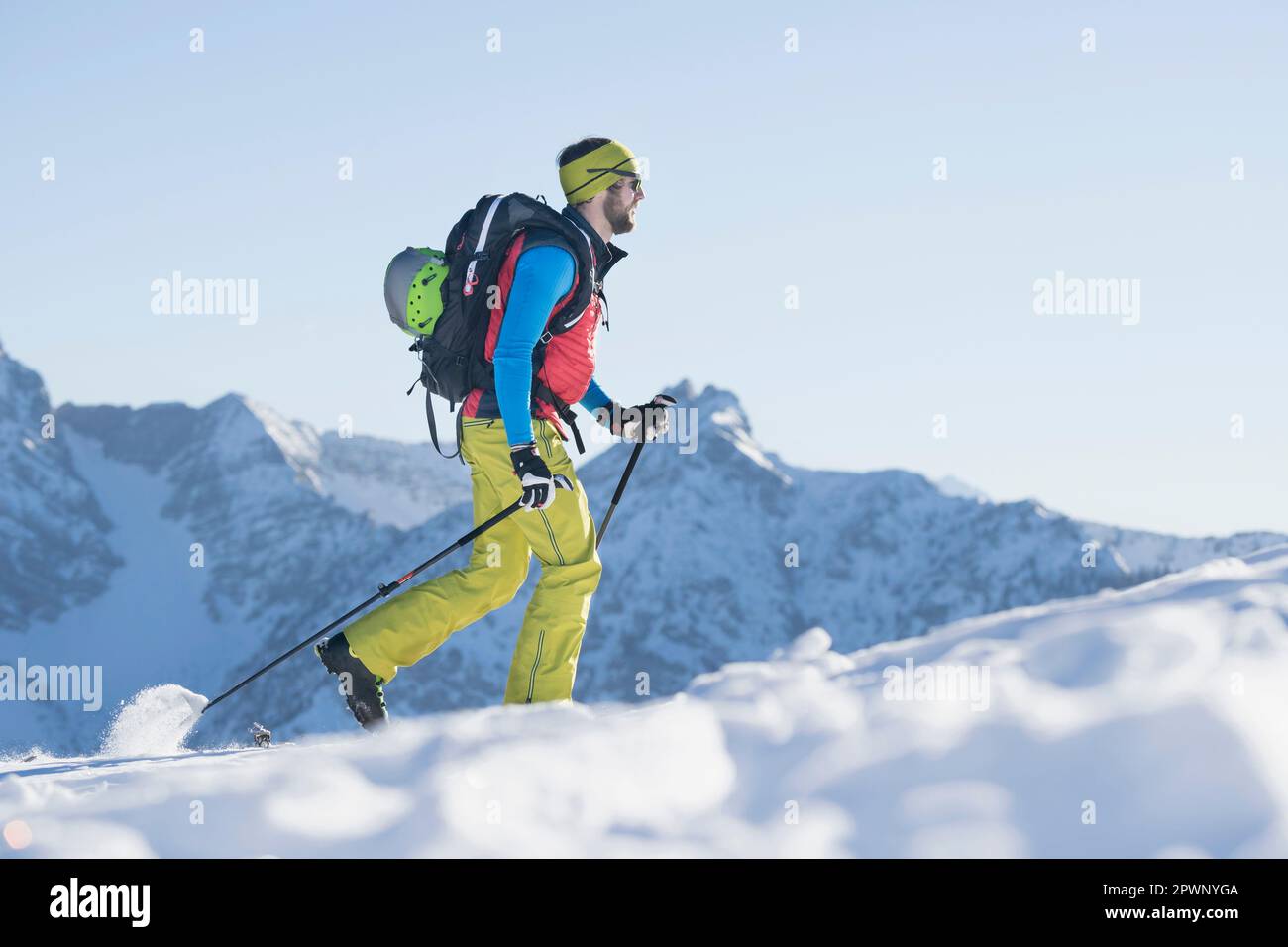 Sciatore che sale su una montagna innevata Foto Stock