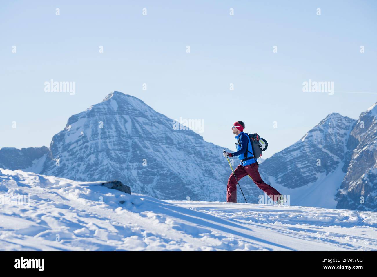 Sciatore che sale su una montagna innevata Foto Stock