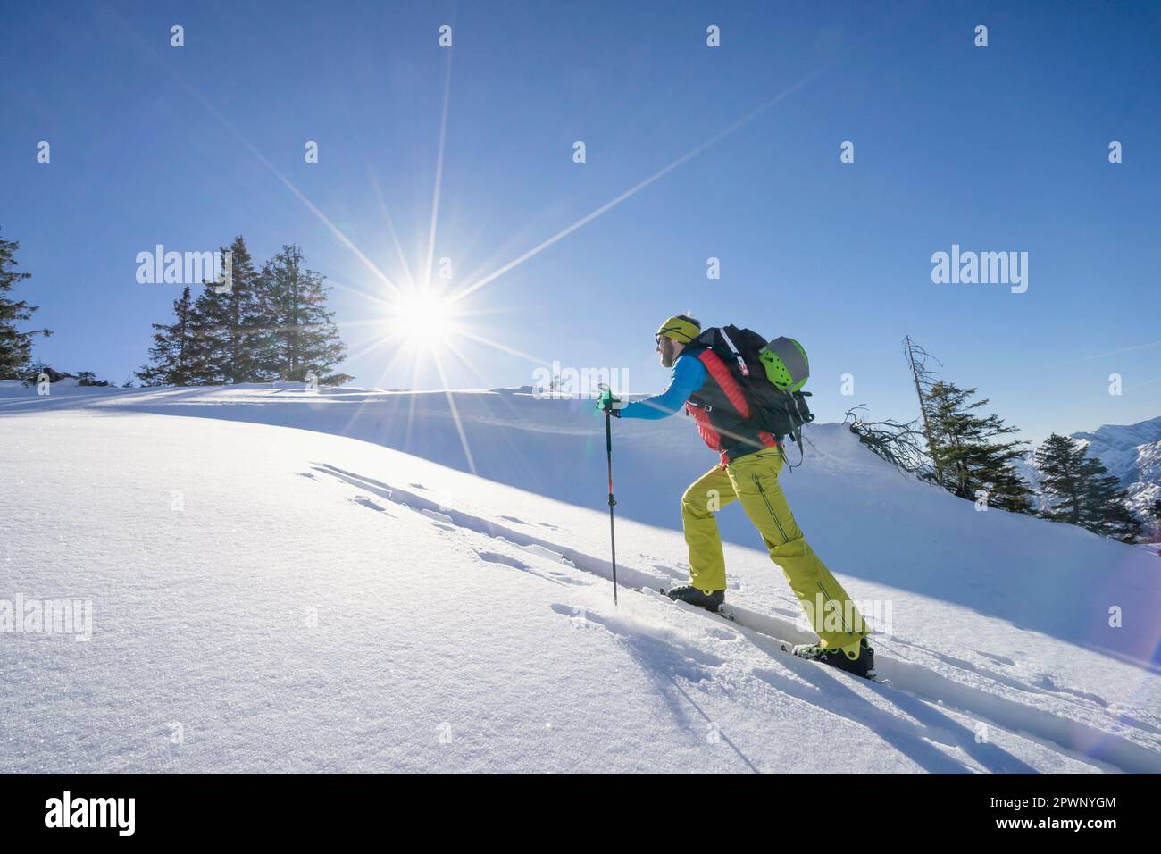 Sciatore che sale su una montagna innevata Foto Stock